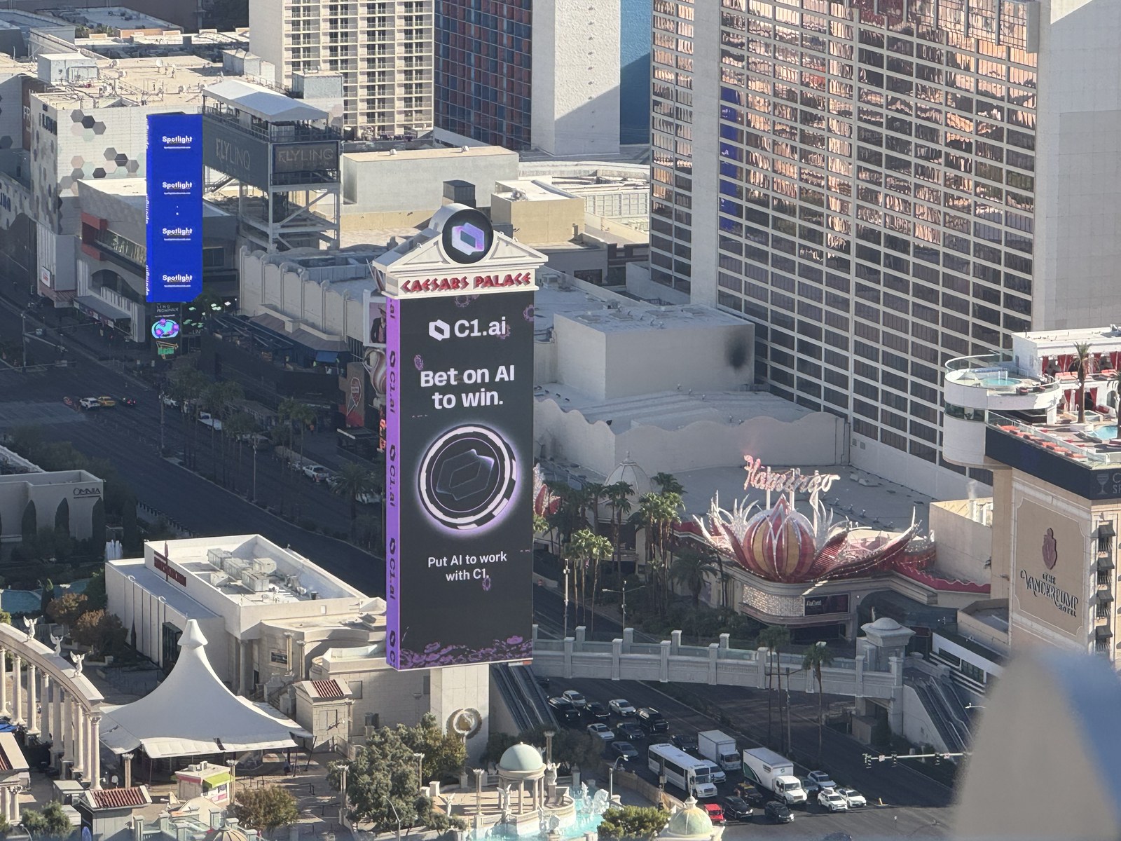 Elevated daytime view of C1's Bet on AI to win advertisement on the Caesars Palace digital spectacular overlooking the Las Vegas Strip