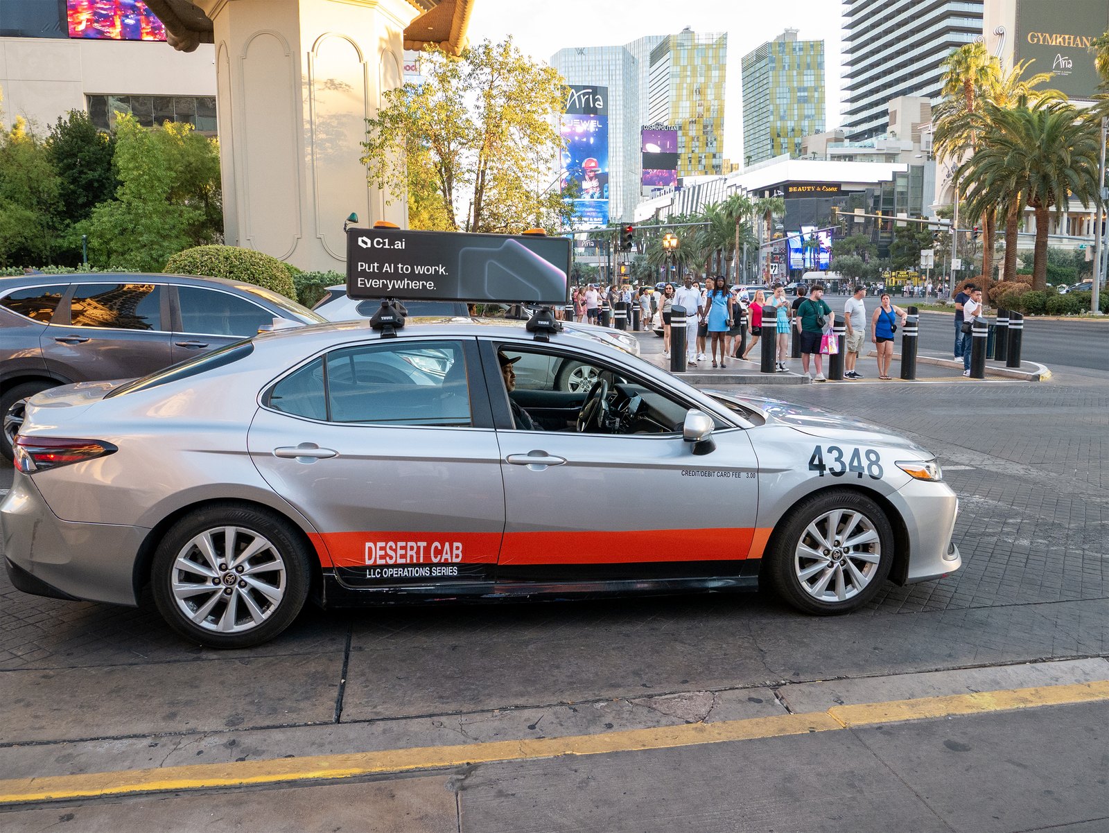 C1 digital taxi top displaying Put AI to work Everywhere with the Las Vegas Strip behind it