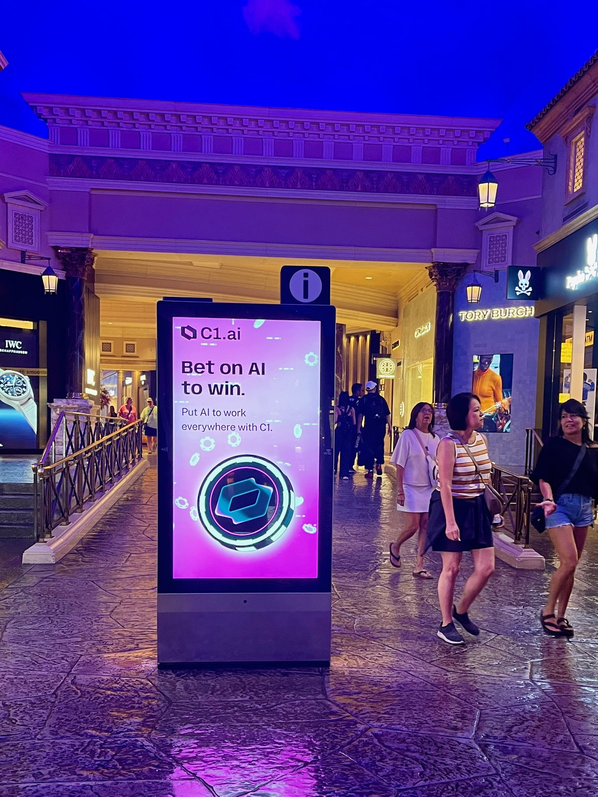 C1 Bet on AI to win digital screen beside storefronts and shoppers inside The Forum Shops