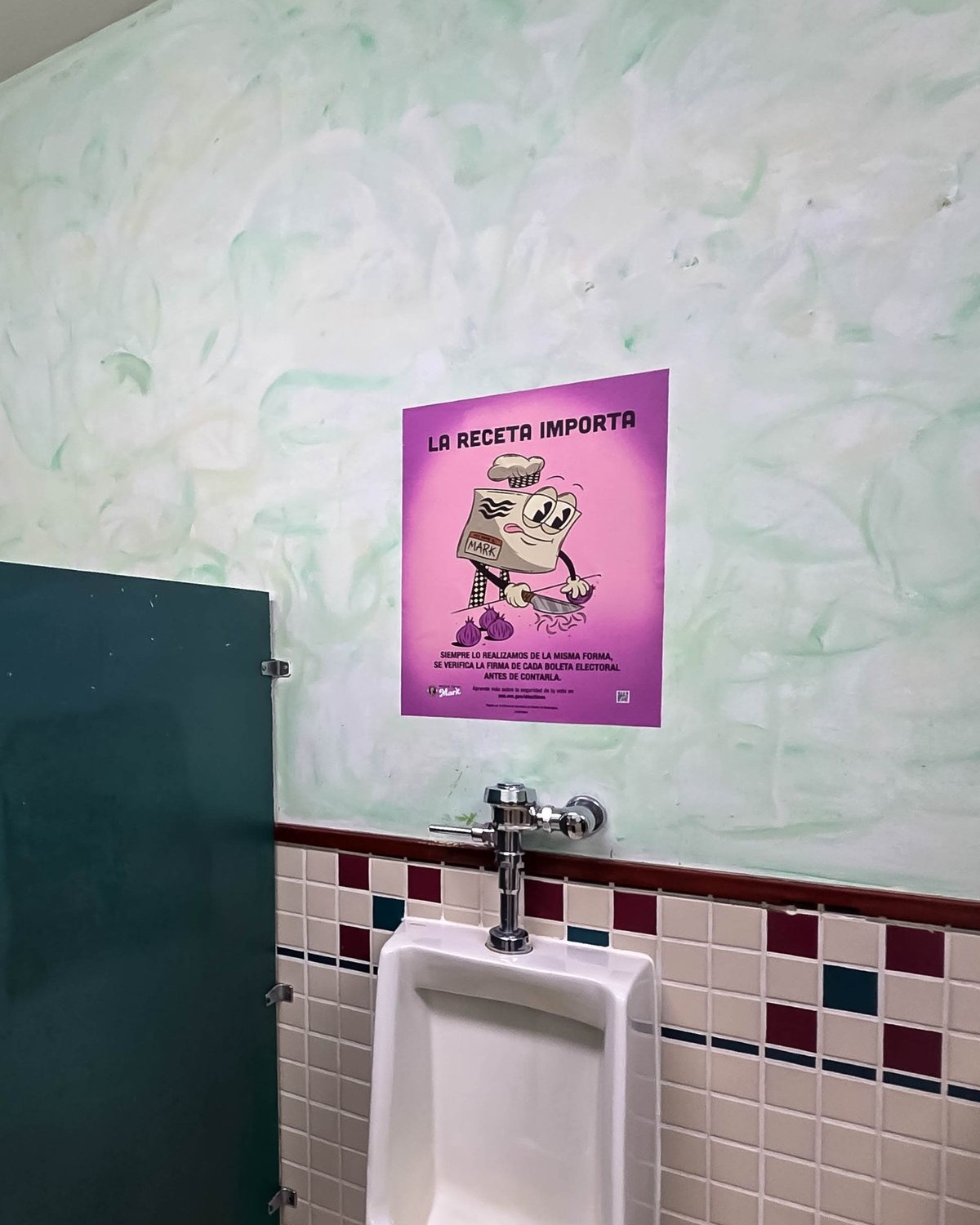 Voter outreach advertising poster displayed inside a restroom as part of the Mark That Ballot campaign